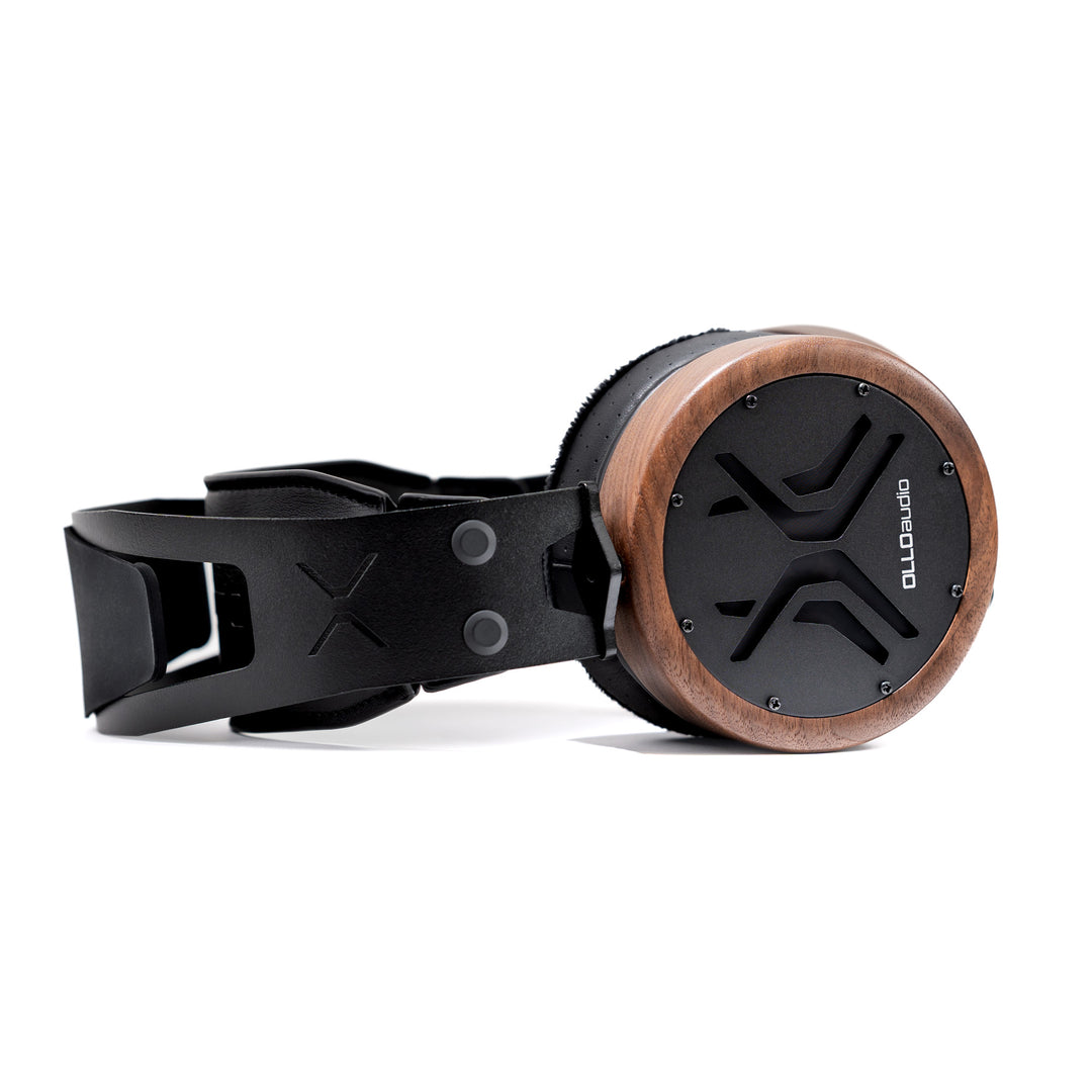 A pair of OLLO Audio X2 over-ear headphones with a black leather strap and headband, featuring a circular wooden-rimmed earcup with a black speaker grille.