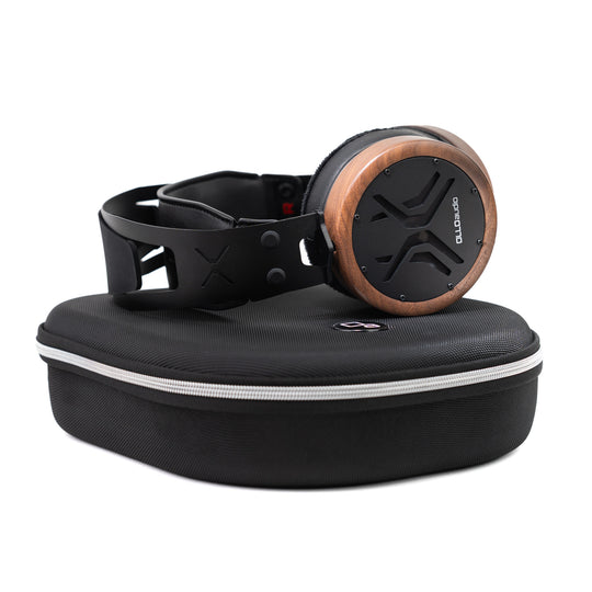 OLLO Audio X2 over-ear headphones with a wood-grain accent on the earcup, resting on a black zippered hard carrying case against a white background.