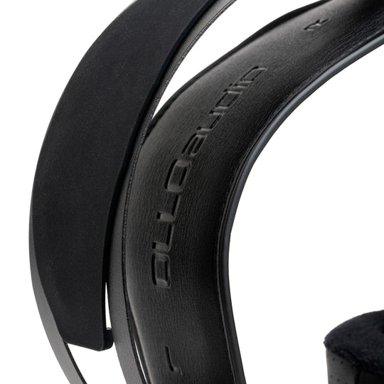 Close-up of a black over-ear headphone headband showing the embossed 'OLLO Audio' brand name on a white background.