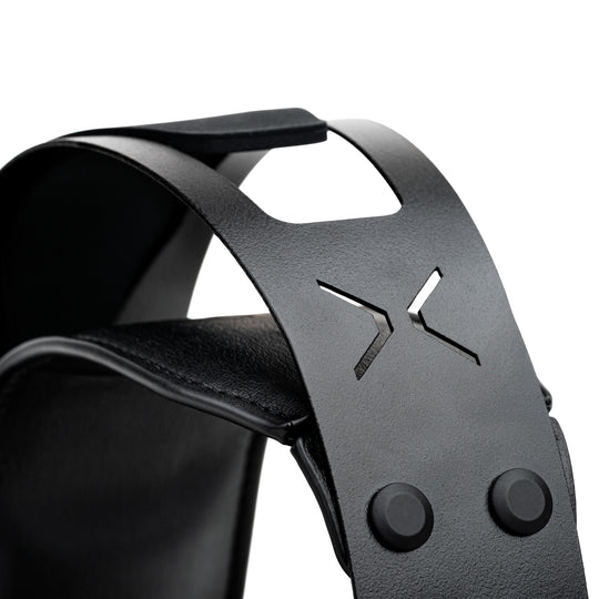 Close-up of a black leather headband with a textured finish, featuring a cutout logo and two snap buttons on a white background.